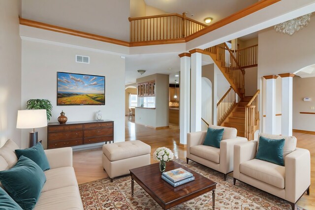 entrance foyer featuring decorative columns, light hardwood / wood-style flooring, and ornamental molding