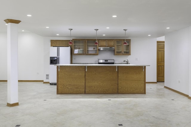 kitchen featuring a kitchen island with sink, stove, decorative light fixtures, and white refrigerator with ice dispenser