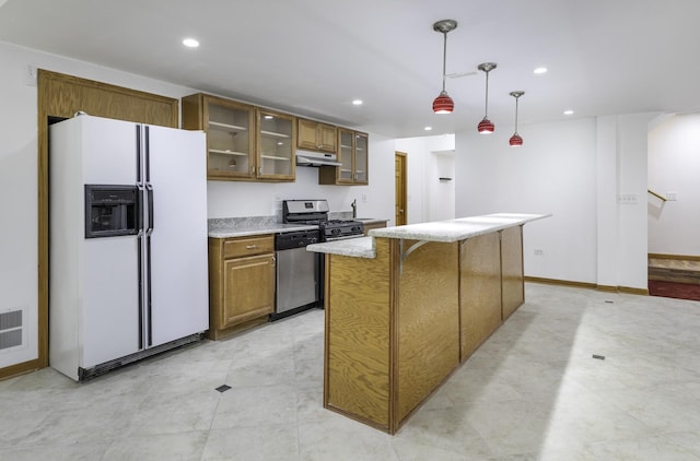 kitchen with stainless steel appliances, a kitchen island, and hanging light fixtures