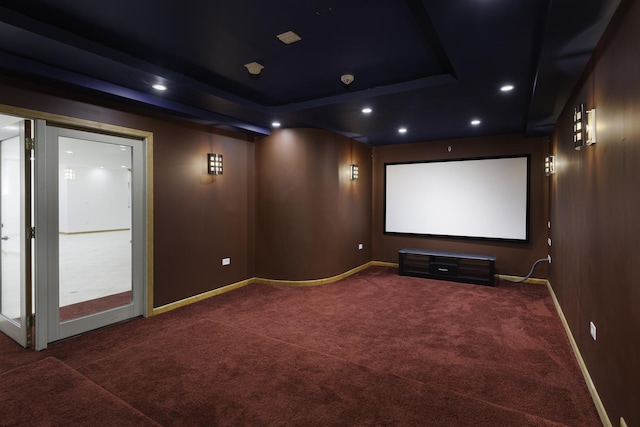 carpeted home theater featuring a tray ceiling