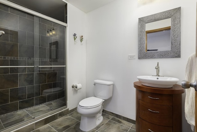 bathroom featuring tile patterned flooring, vanity, toilet, and a shower with door