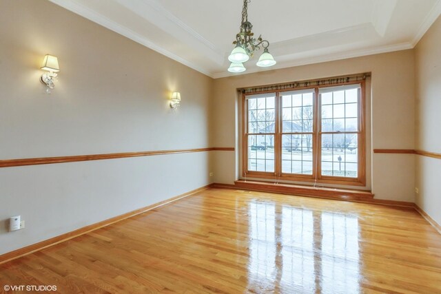 entrance foyer with a healthy amount of sunlight, an inviting chandelier, a towering ceiling, ornate columns, and light hardwood / wood-style floors