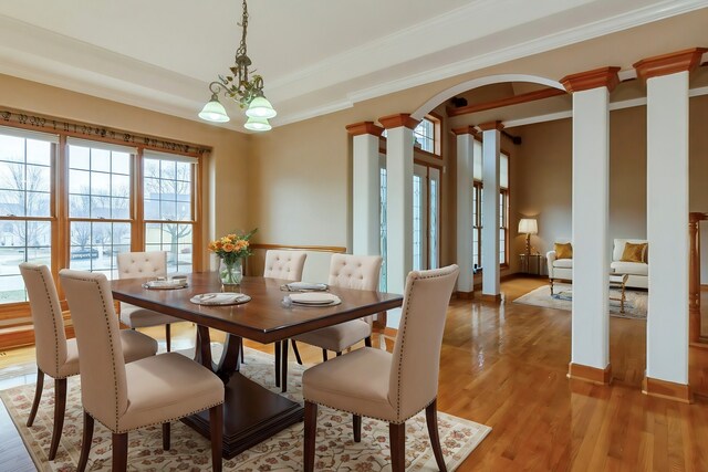 foyer entrance with decorative columns, a towering ceiling, and light hardwood / wood-style floors