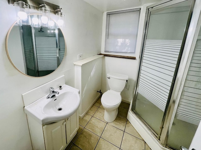 bathroom with tile patterned flooring, vanity, toilet, and an enclosed shower