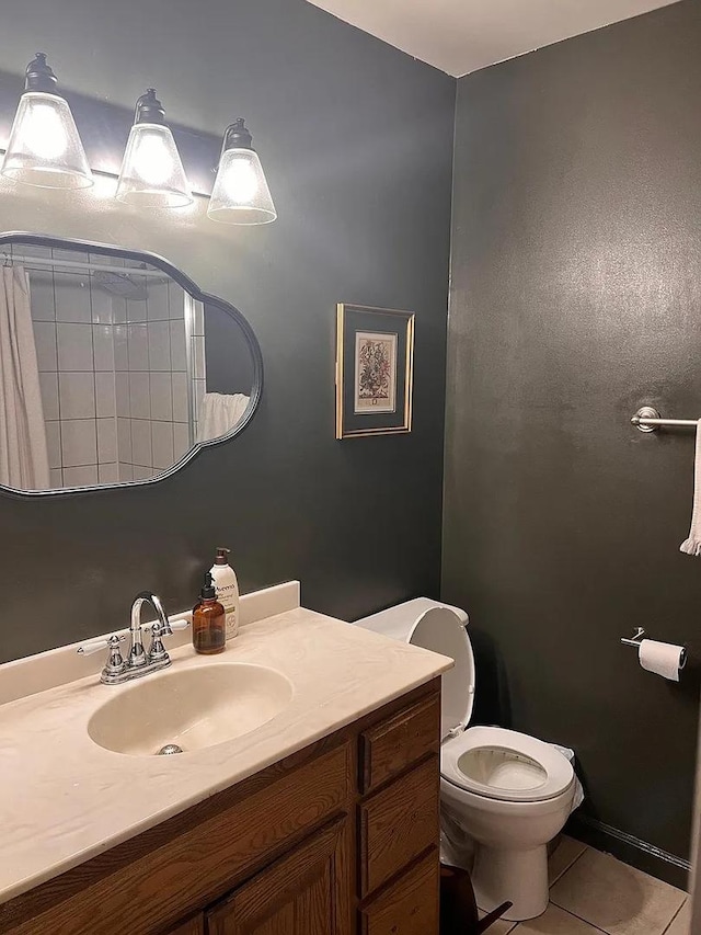 bathroom featuring tile patterned flooring, vanity, and toilet