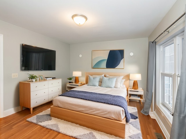 bedroom featuring wood-type flooring and multiple windows