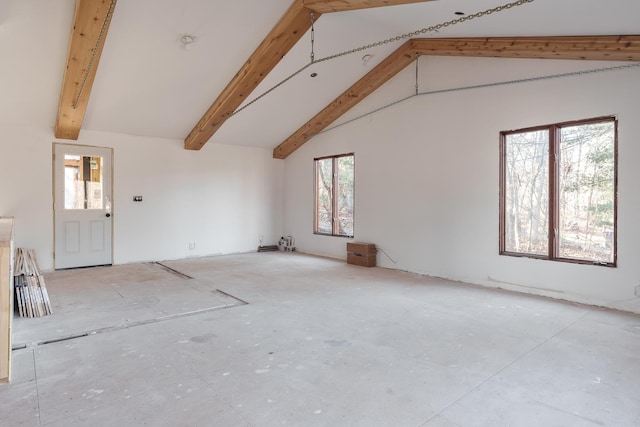 unfurnished living room with beam ceiling and high vaulted ceiling