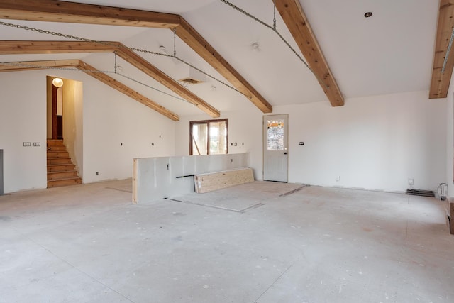 unfurnished living room featuring lofted ceiling with beams