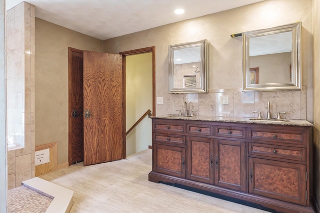 bathroom with vanity and tasteful backsplash