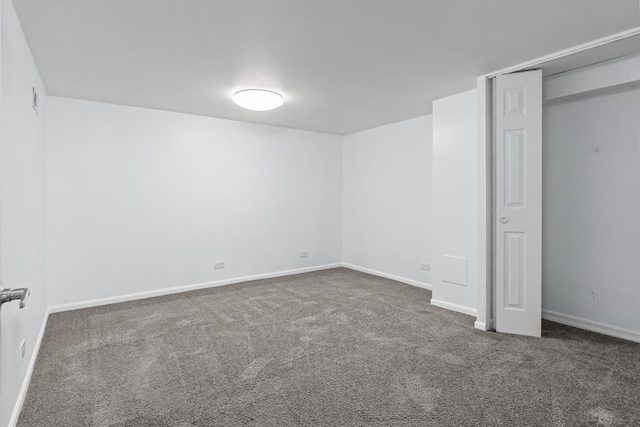 unfurnished bedroom featuring dark carpet and a closet