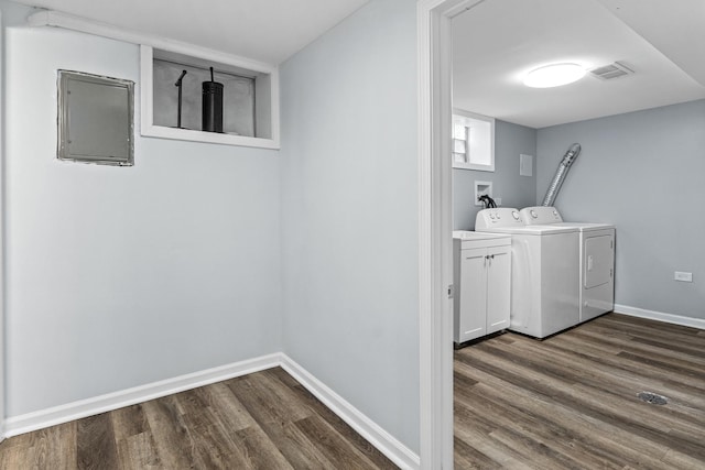 clothes washing area with dark hardwood / wood-style floors, cabinets, and separate washer and dryer