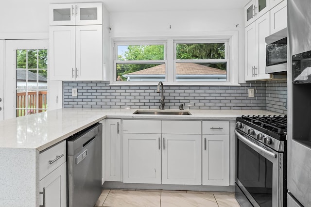 kitchen with appliances with stainless steel finishes, white cabinetry, and sink