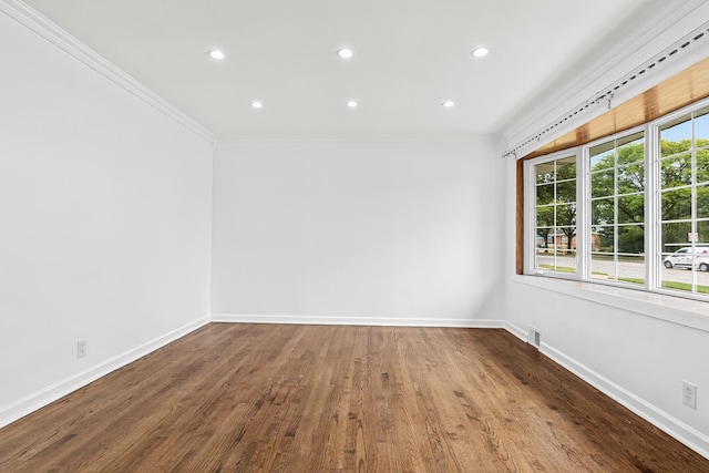 empty room with wood-type flooring and crown molding