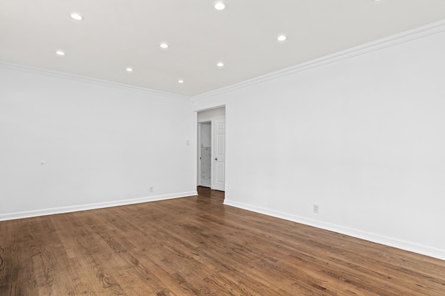 spare room featuring dark wood-type flooring and crown molding