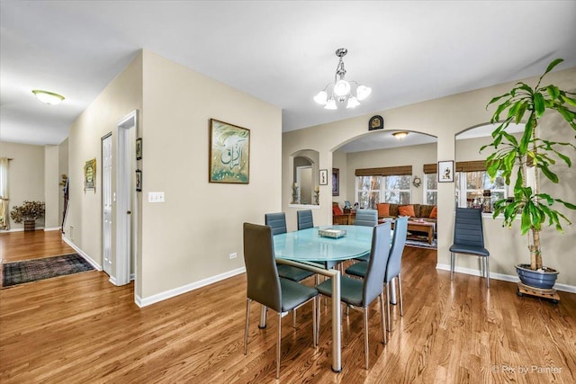 dining area featuring light wood-type flooring and an inviting chandelier