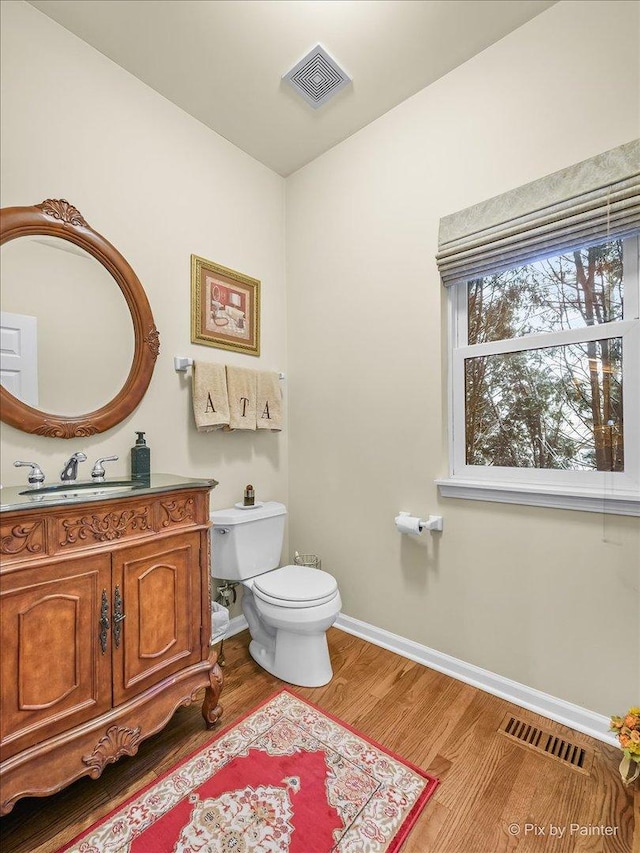 bathroom featuring hardwood / wood-style floors, vanity, and toilet