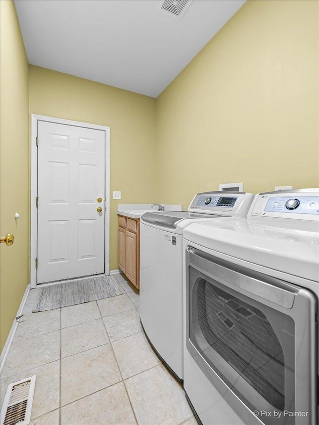 washroom with light tile patterned flooring, cabinets, and independent washer and dryer