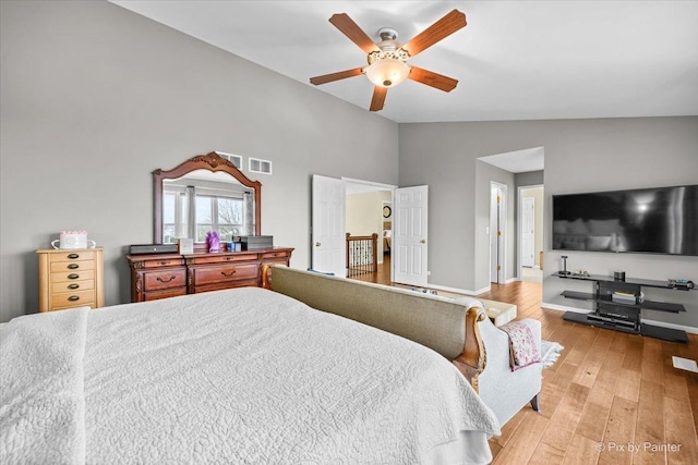 bedroom with light hardwood / wood-style floors, vaulted ceiling, and ceiling fan