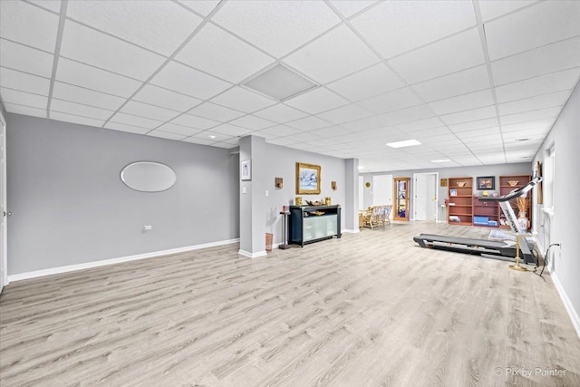 interior space with a drop ceiling and light wood-type flooring