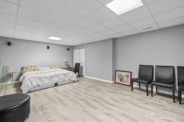 bedroom with light hardwood / wood-style flooring and a drop ceiling