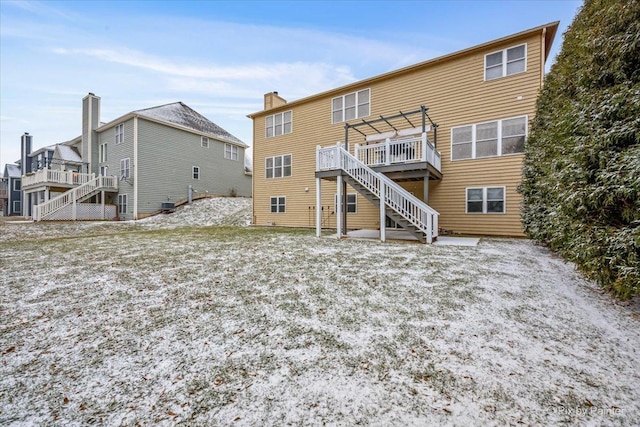 rear view of property featuring a pergola and a deck