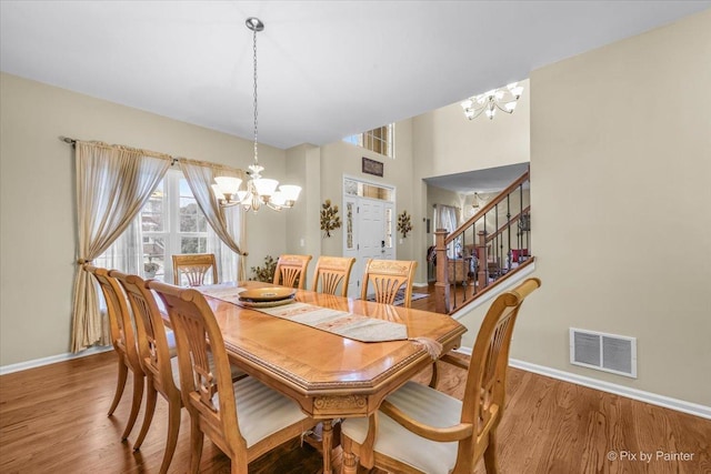 dining area featuring hardwood / wood-style flooring and a notable chandelier