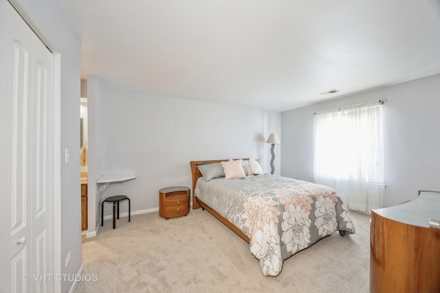 bedroom with light colored carpet and a closet