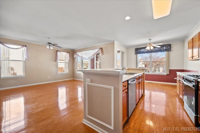 kitchen featuring ornamental molding, a kitchen island with sink, light hardwood / wood-style flooring, and appliances with stainless steel finishes