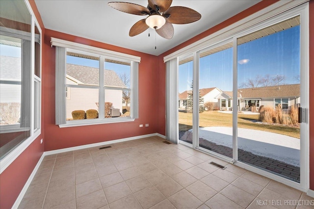 spare room with ceiling fan and light tile patterned floors