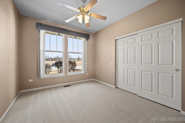 unfurnished bedroom featuring light colored carpet, ceiling fan, and a closet