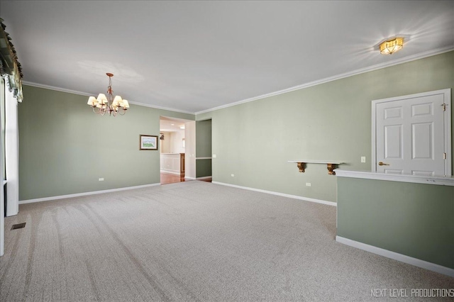 spare room with an inviting chandelier, ornamental molding, and light colored carpet