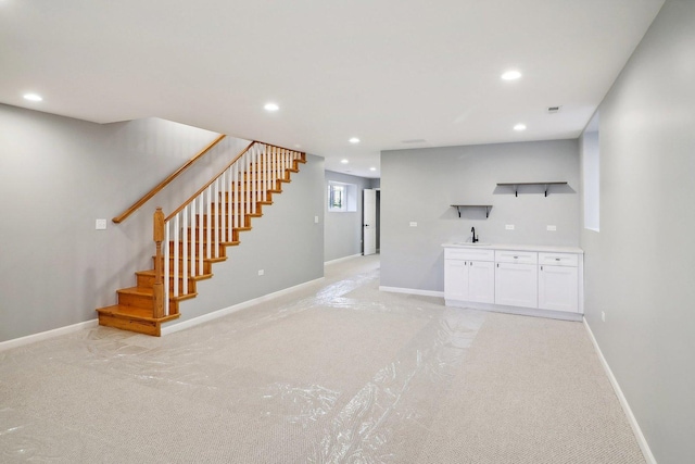 unfurnished living room with light colored carpet and sink