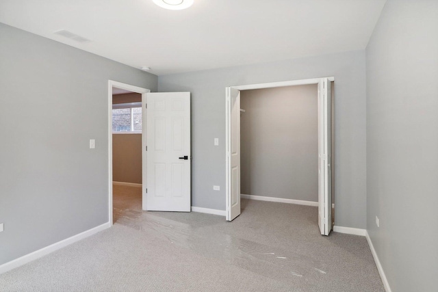 unfurnished bedroom featuring light carpet and a closet