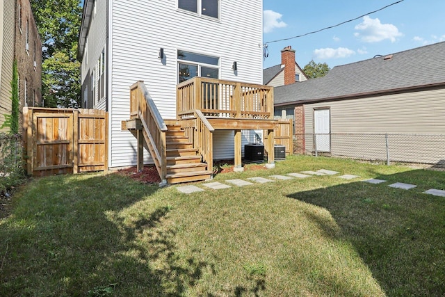 back of property with cooling unit, a yard, and a wooden deck