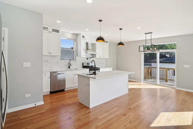 kitchen with hanging light fixtures, white cabinetry, a kitchen island with sink, and appliances with stainless steel finishes