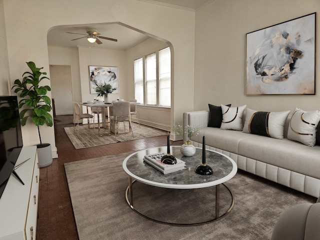 living room with dark hardwood / wood-style floors, ceiling fan, and crown molding