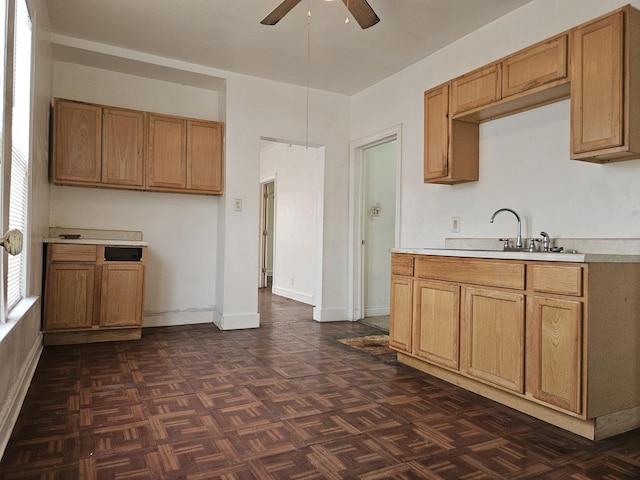 kitchen with dark parquet floors, ceiling fan, and sink