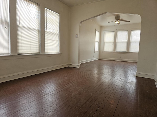 empty room with ceiling fan, dark hardwood / wood-style flooring, plenty of natural light, and ornamental molding