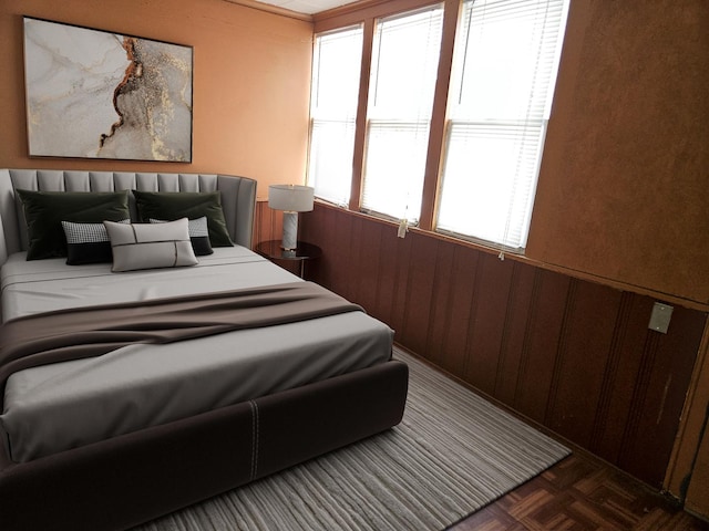 bedroom with dark parquet flooring and wooden walls