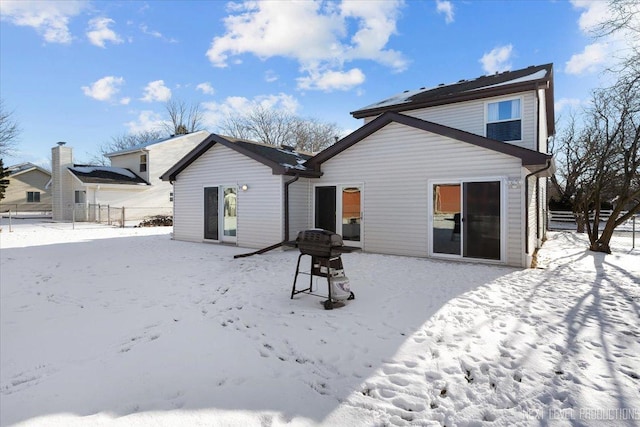 view of snow covered back of property