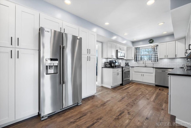 kitchen featuring stainless steel appliances, dark wood-type flooring, white cabinets, and sink