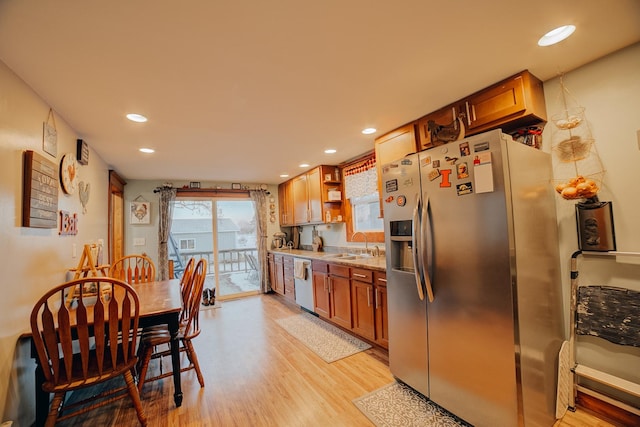 kitchen with sink, stainless steel appliances, and light wood-type flooring