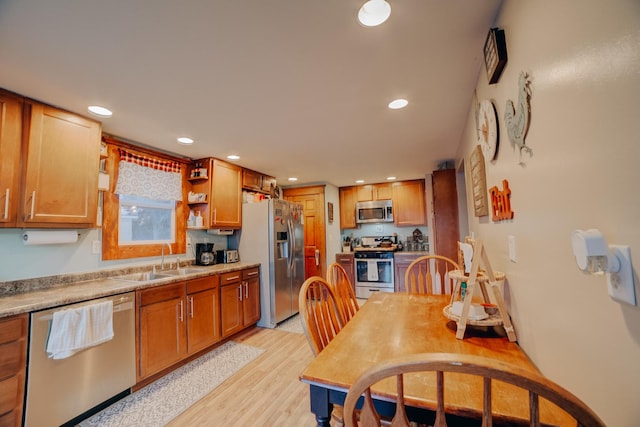 kitchen with sink, stainless steel appliances, and light hardwood / wood-style floors