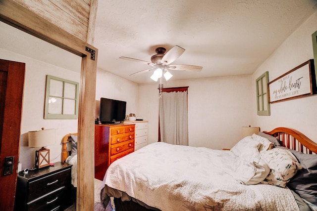 bedroom with ceiling fan and a textured ceiling