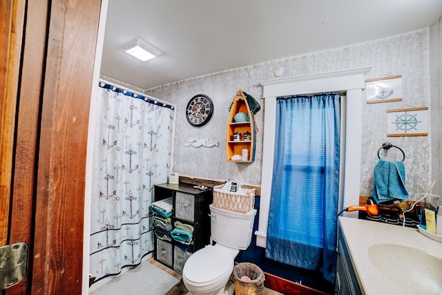 bathroom with toilet, vanity, and curtained shower