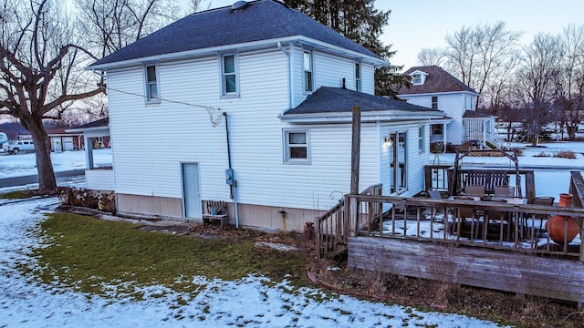 snow covered house with a deck