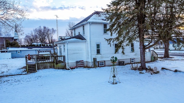 view of snow covered exterior featuring central AC unit and a deck