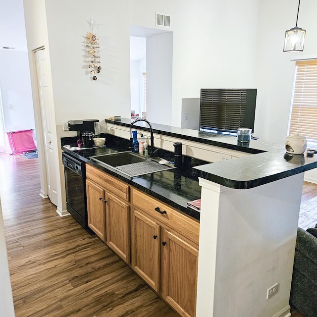 kitchen featuring dishwasher, dark hardwood / wood-style flooring, sink, and hanging light fixtures