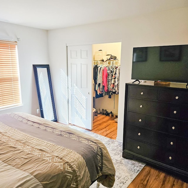 bedroom with hardwood / wood-style flooring, a spacious closet, and a closet