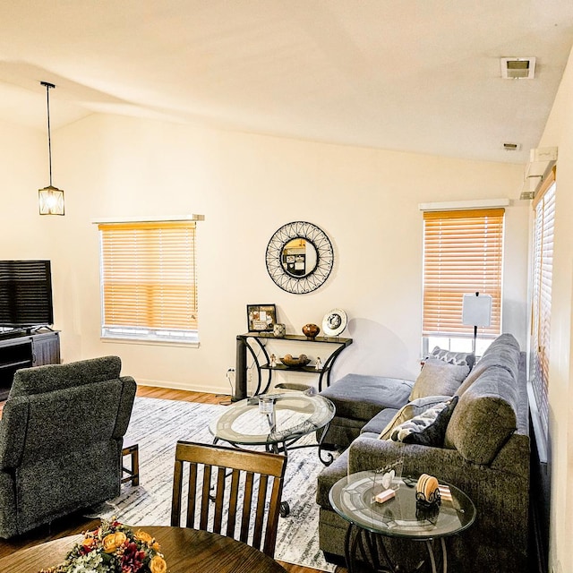 living room featuring lofted ceiling and light hardwood / wood-style flooring